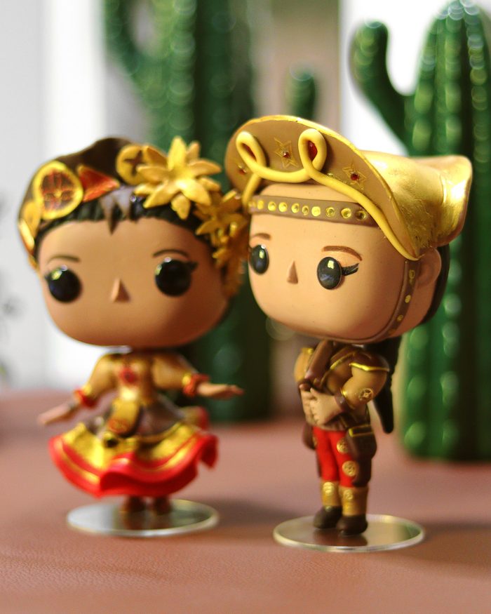Dupla de personagens dourados em biscuit